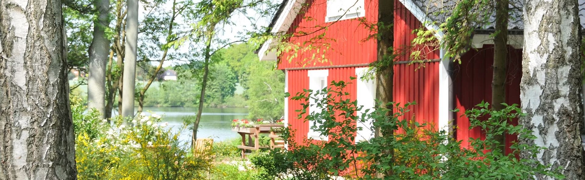 Rotes Holzhaus mit weißen Fensterläden